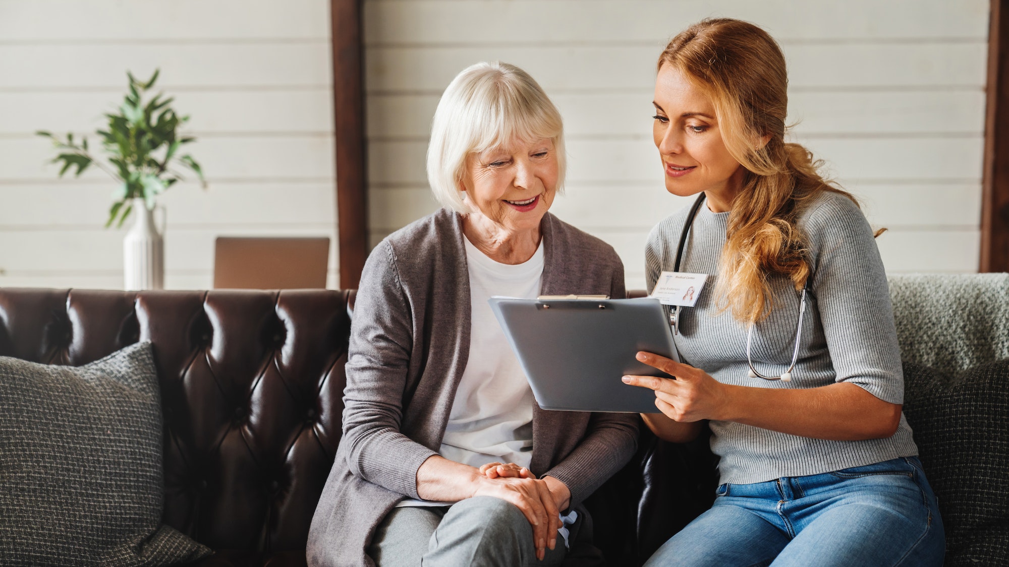 front-view-shot-of-caring-young-woman-nurse-help-old-granny-during-homecare-medical-visit